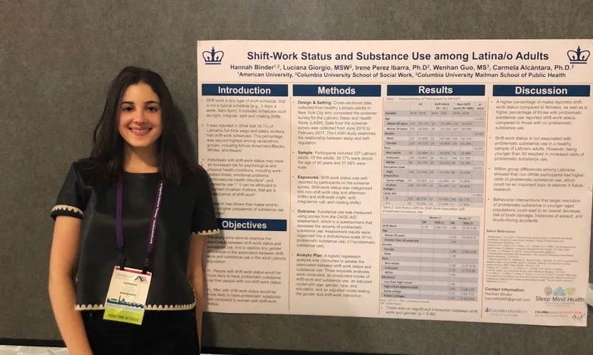 Hannah stands in front of there scientific poster presentation